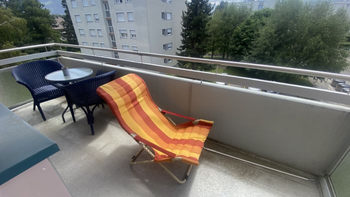 Balkon mit Sitzmöbeln und Ausblick ins Grüne