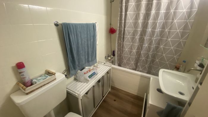 Kleines Badezimmer mit Badewanne und Duschvorhang