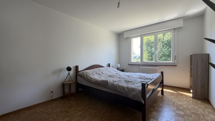 Helles Schlafzimmer mit Doppelbett und Fenster